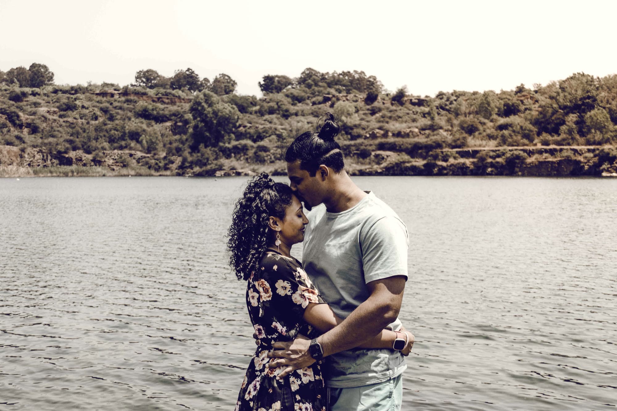 Andrew and Latisha by a lake, holding each other.